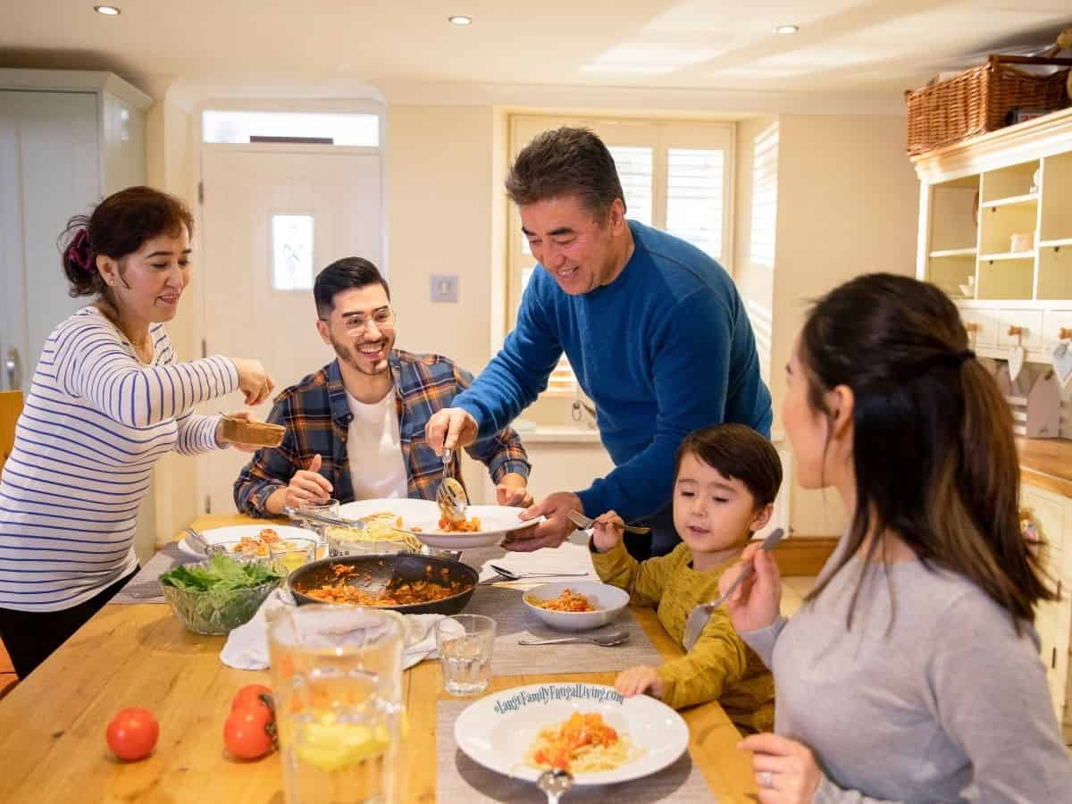 Family around dinner table; father dishing food
