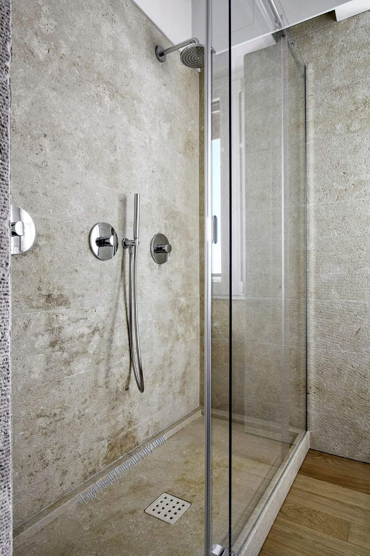 Glass door and enclosure on a stone shower base and walls