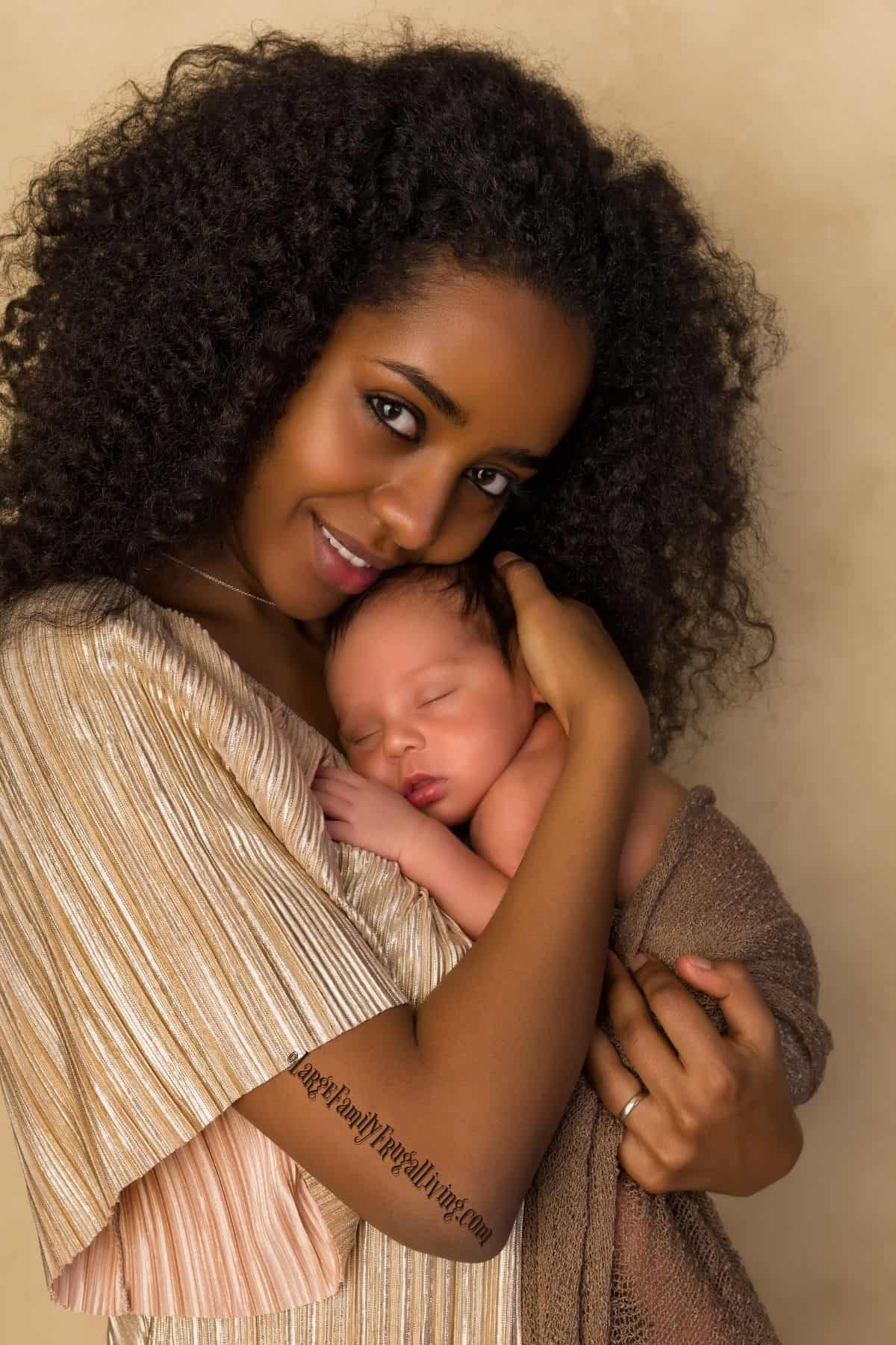 Smiling mother in gold dress with her newborn baby
