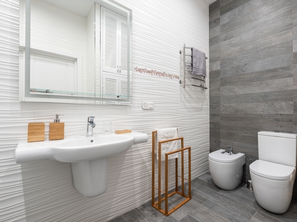 Bright and minimal bathroom with white and grey tile covering floor and walls and white modern fixtures