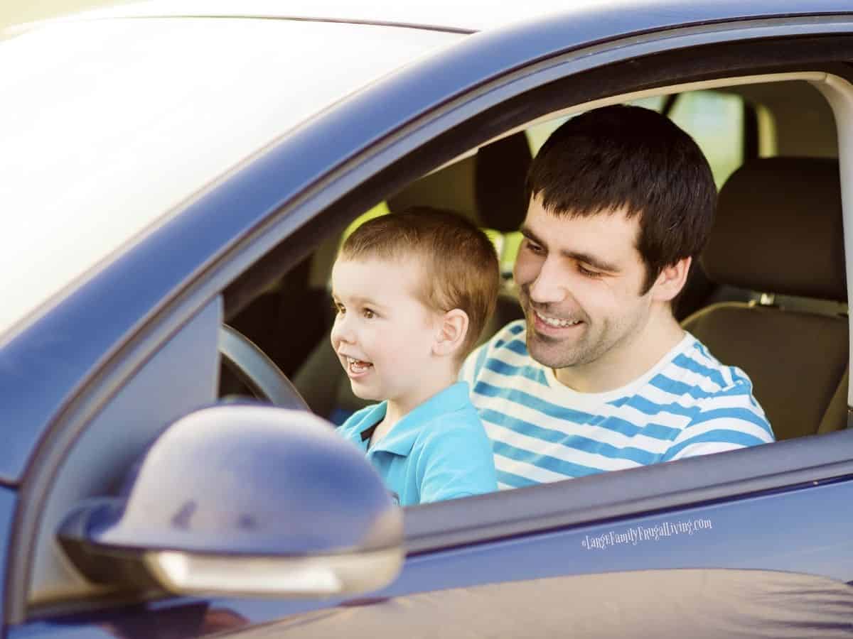 Father and young son sitting at the wheel of their car