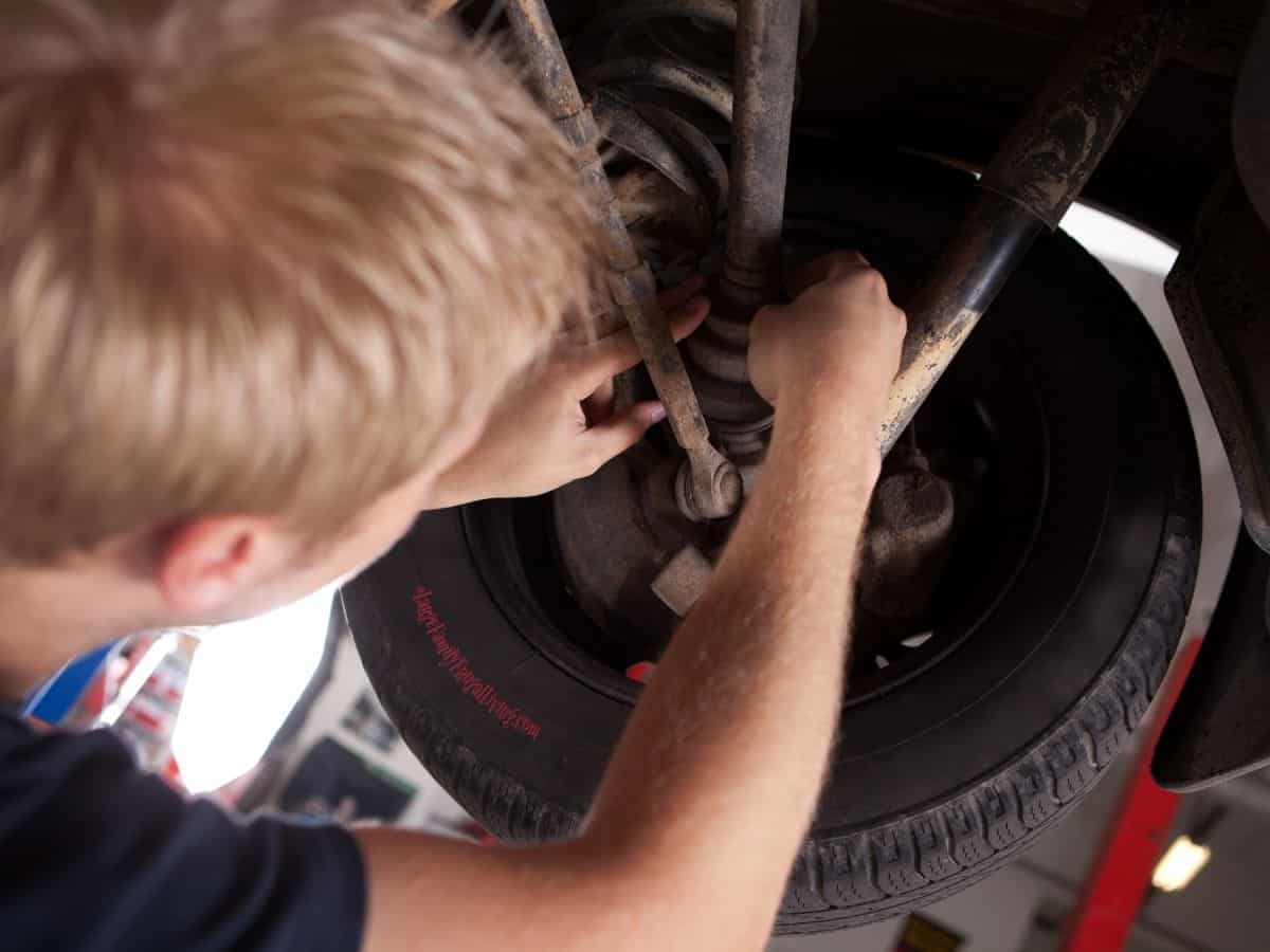 Mechanic inspecting cv joint on car on a lift