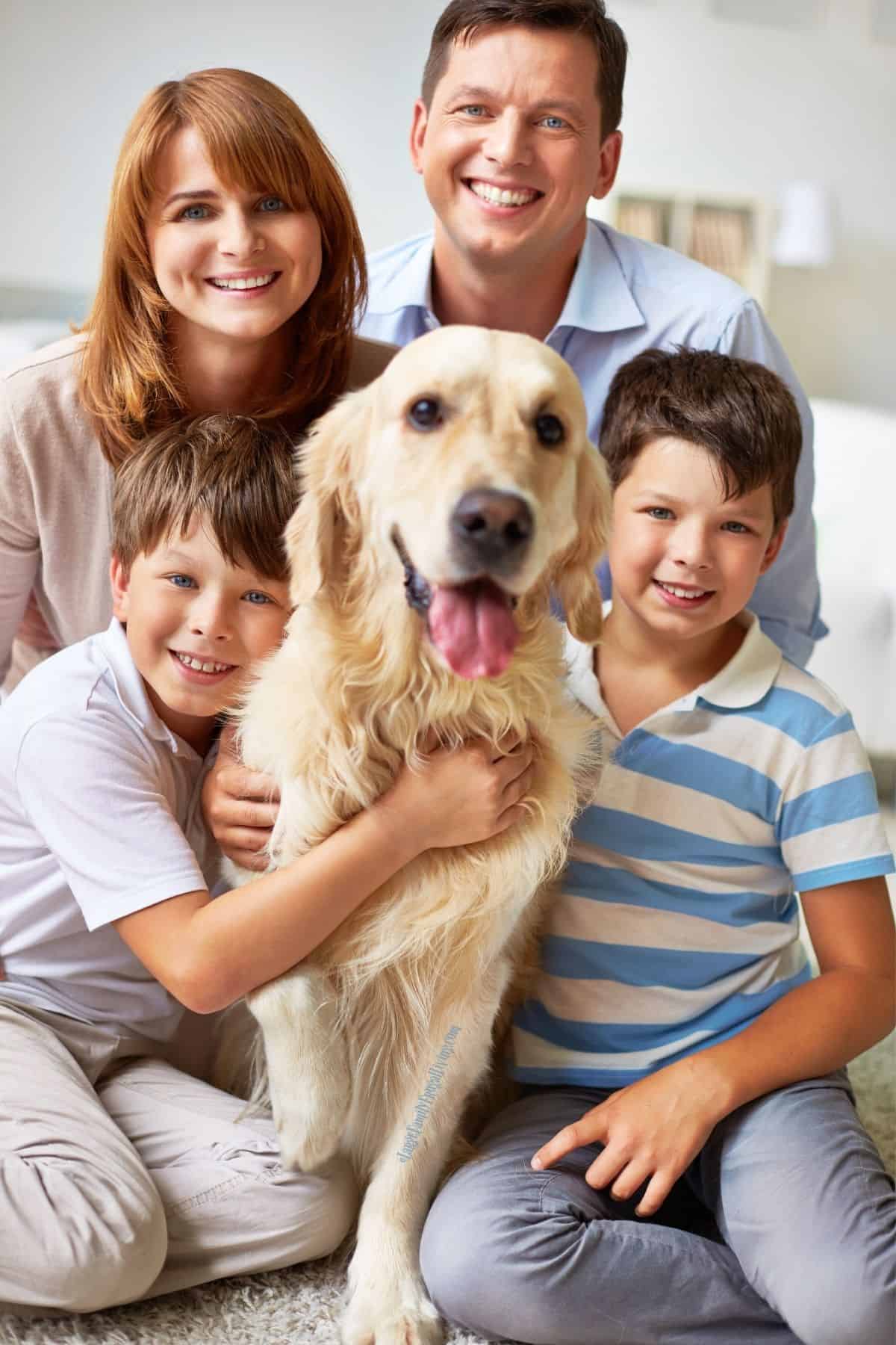 Happy family of four posing with their older dog