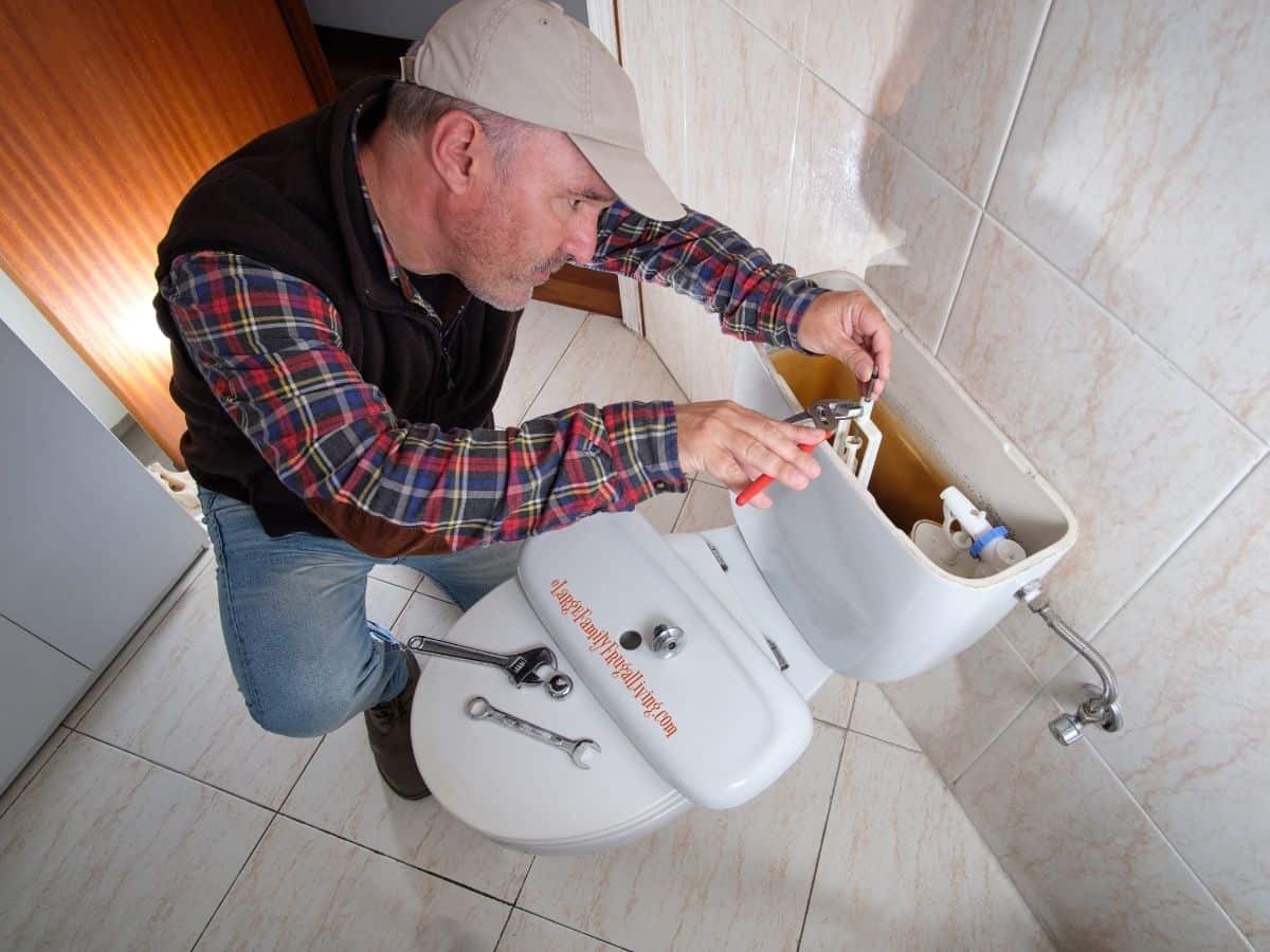 Plumber repairing parts in toilet tank