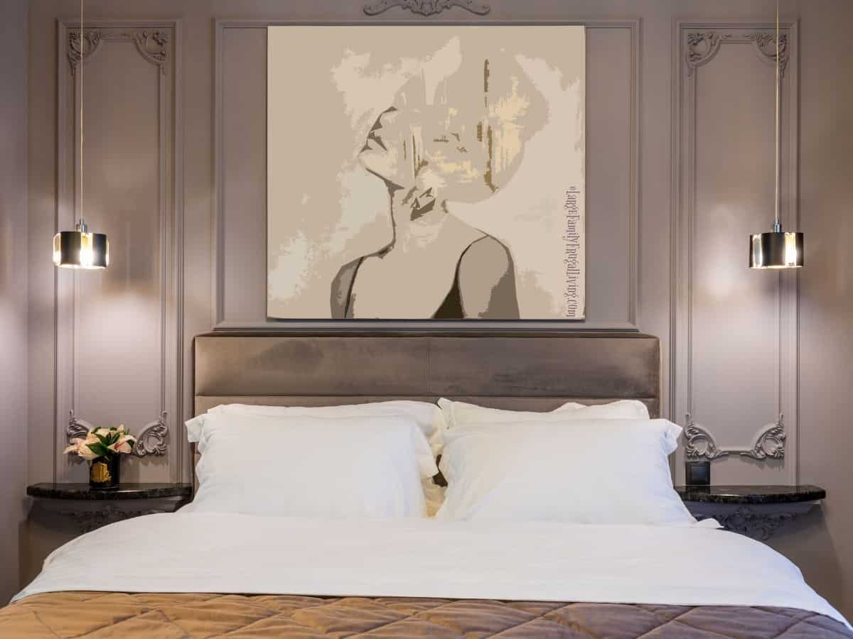 Modern bedroom painted in soft purple with artwork hanging above soft bed