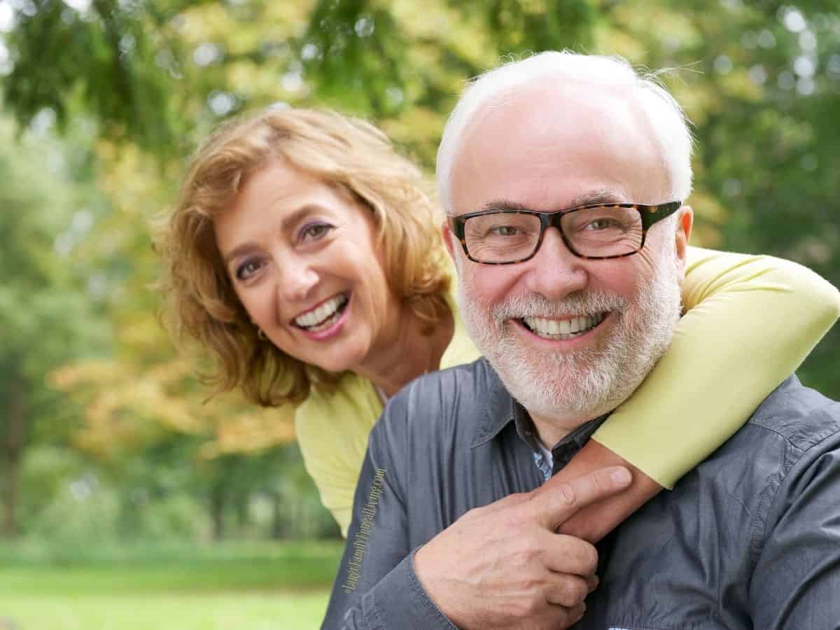 Happy older woman embracing smiling older man