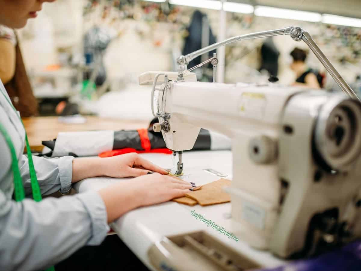 Female hands guiding thick fabric at heavy duty sewing machine