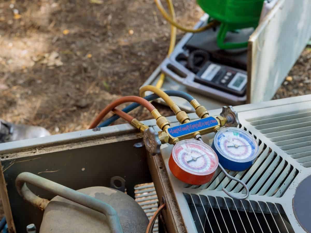 Checking air conditioning heating unit outside residential housing