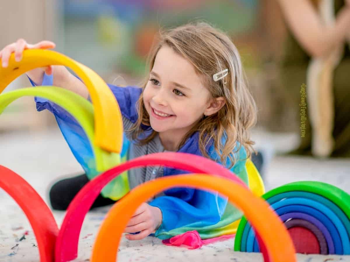 A young girl in preschool playing with colorful semicircle toys
