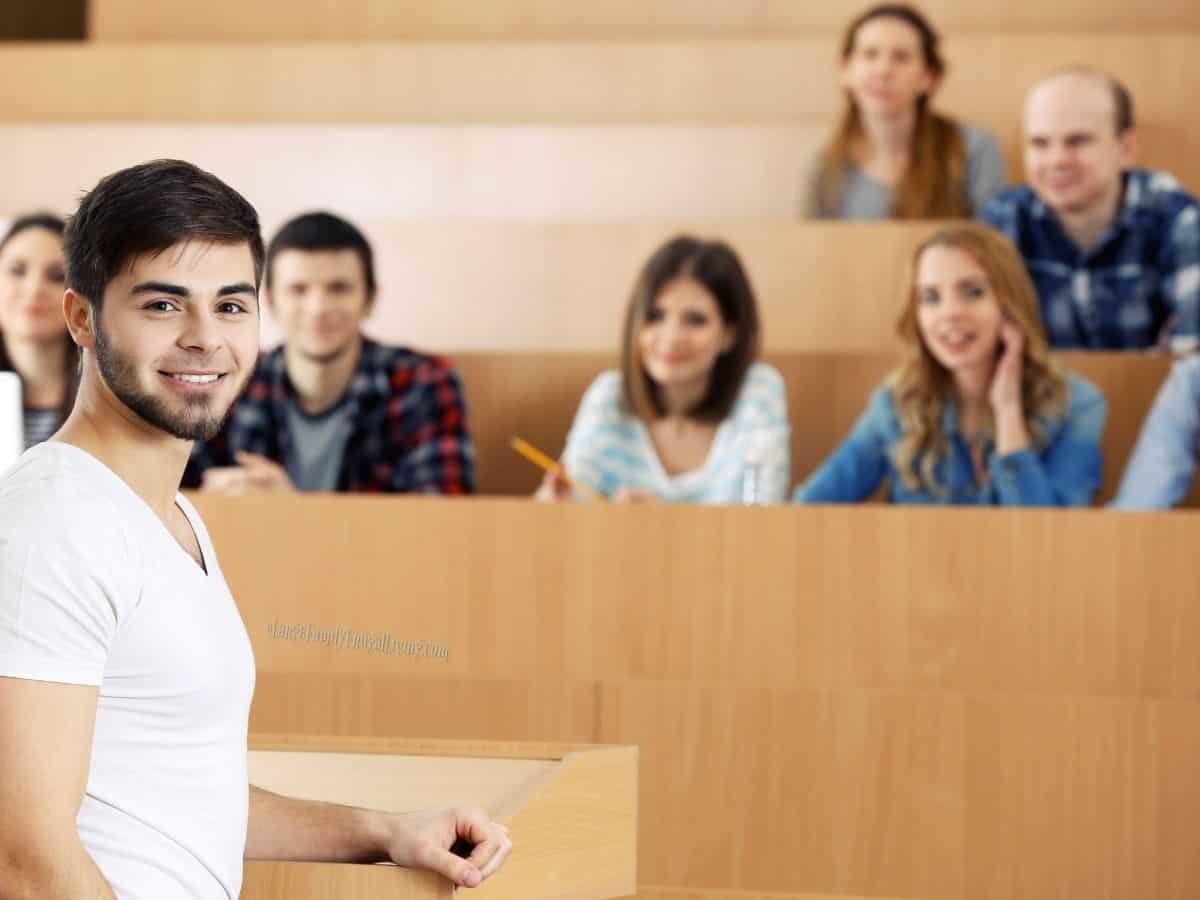 Group of students sitting in lecture hall or classroom listening to speaker