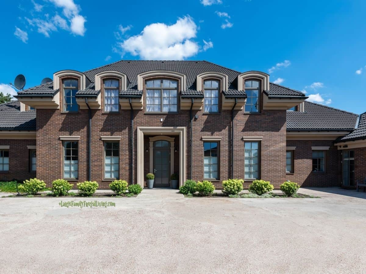 Large custom brown brick home with high-end tile roof
